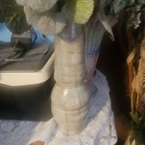 This is an off-white or cream-colored ceramic vase with an organic shape